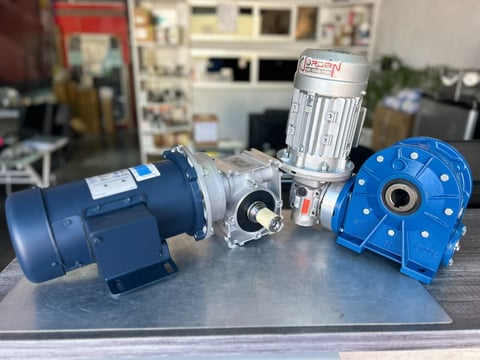 Industrial motor components and gearbox assembly displayed on a table in a workshop setting