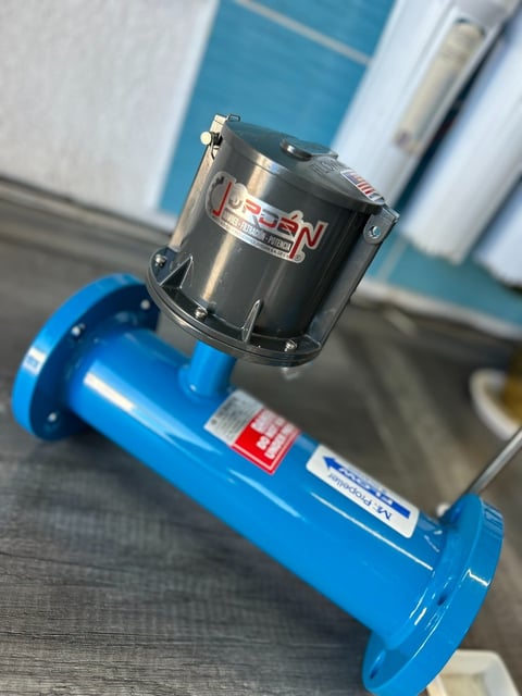 Black and metallic electric motor mounted on top of a blue industrial pump assembly indoors