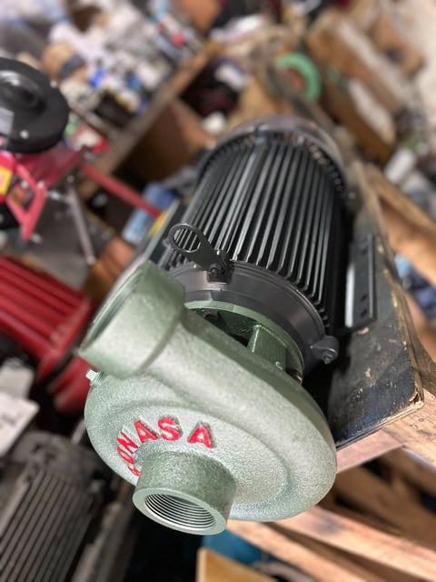 Black electric motor with green NASA labeled housing mounted on red metal frame in workshop setting