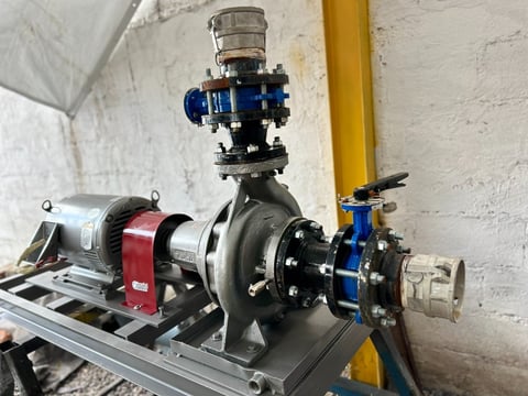 Industrial centrifugal pump assembly with red motor, pressure gauge, and blue valve mounted on base frame